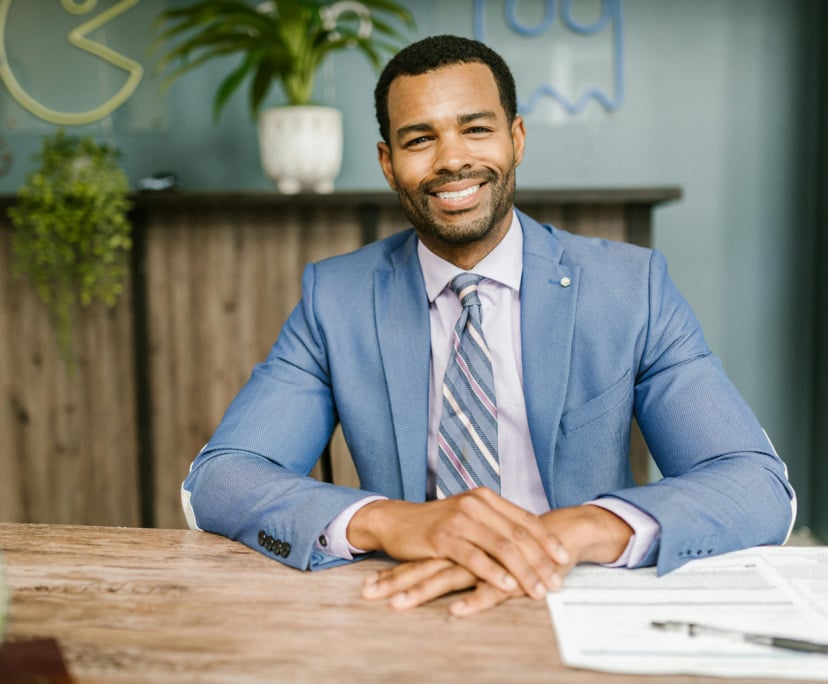 Smiling Freedom Capital financial advisor in blue suit at Adelaide office desk