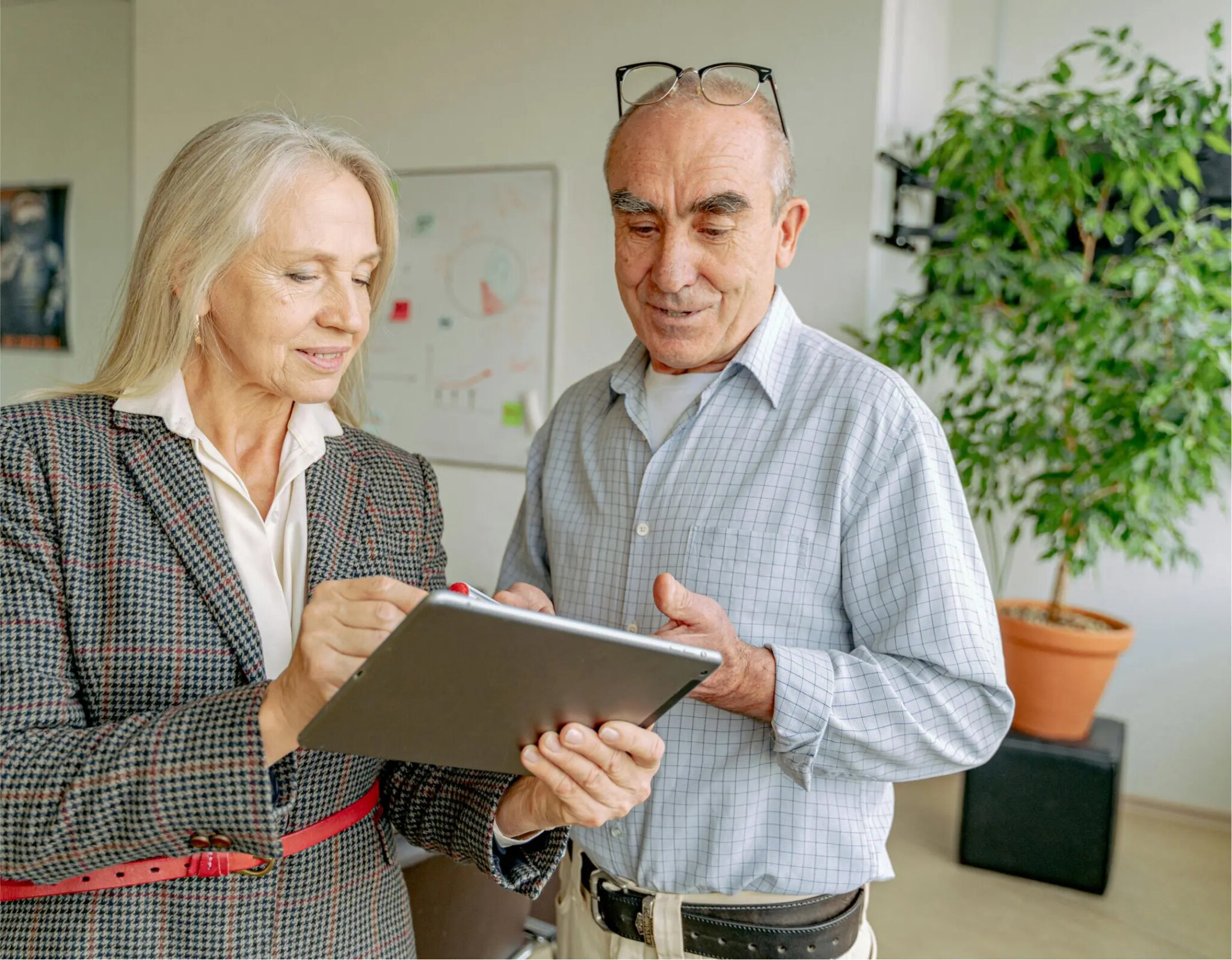 Senior couple in Freedom Capital Solutions office discussing home loan options on tablet