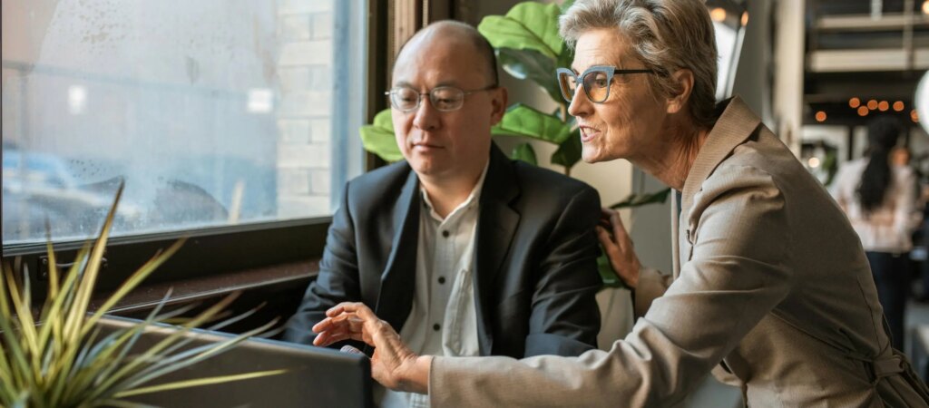 Female mortgage broker advising male client on laptop in modern Melbourne office